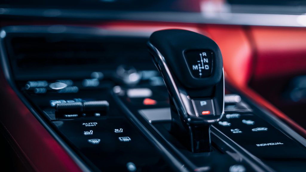 Detailed view of an automatic car gear shifter in a sleek car interior.