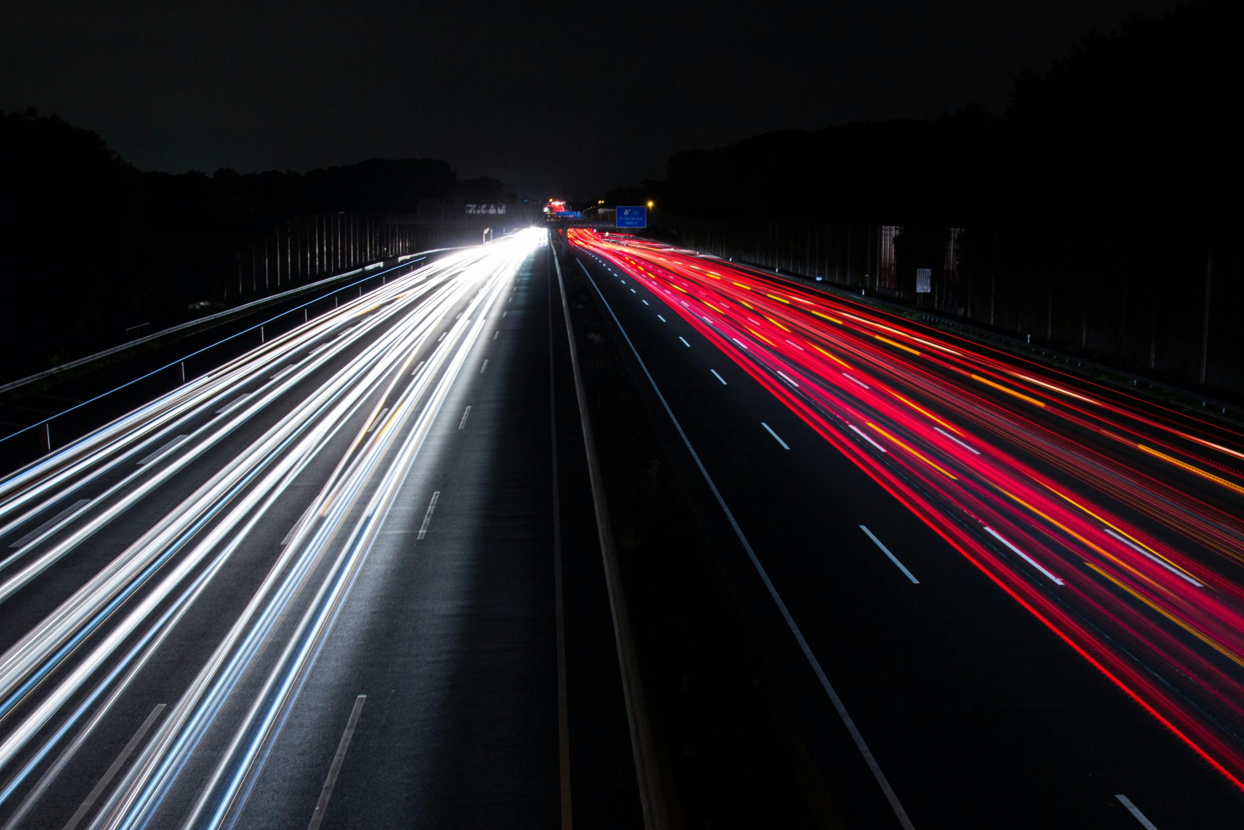 Long exposure of colorful light trails on a highway, capturing the night motion.